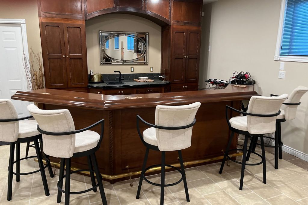 Home wooden bar in basement of home with barstools
